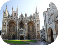 Peterborough's Norman Cathedral on a bright day with the sun lighting up the golden colour of the limestone.